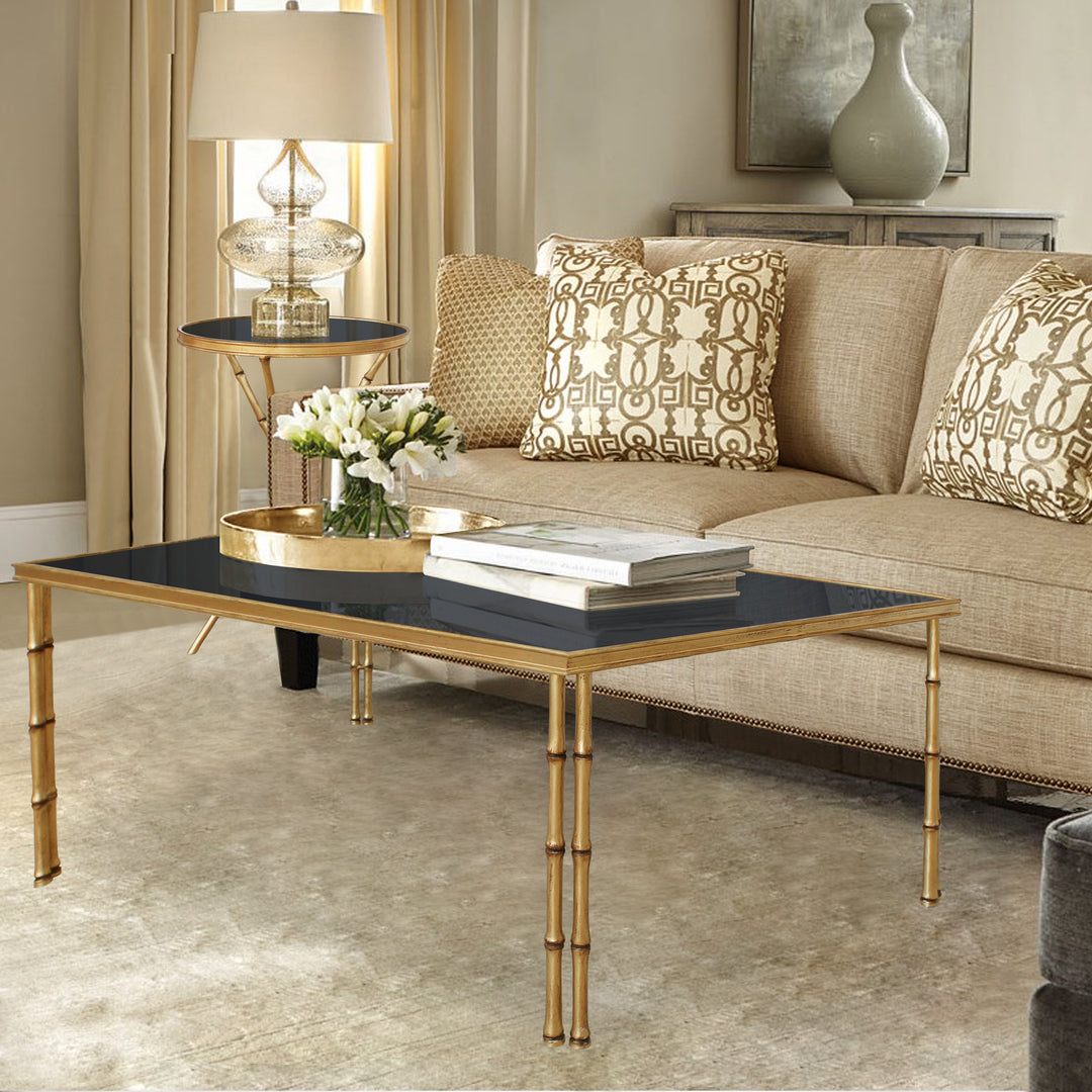 Ruby rectangular center table with bamboo-style legs and black glass top.