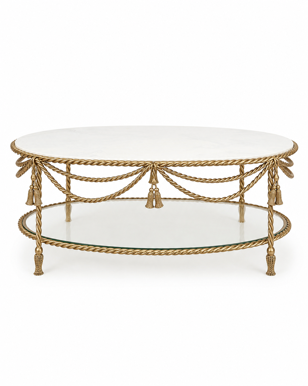 An oval coffee table featuring a white marble top, a gold rope-finish metal frame with decorative tassels, and a lower glass shelf, shown against a plain white background.