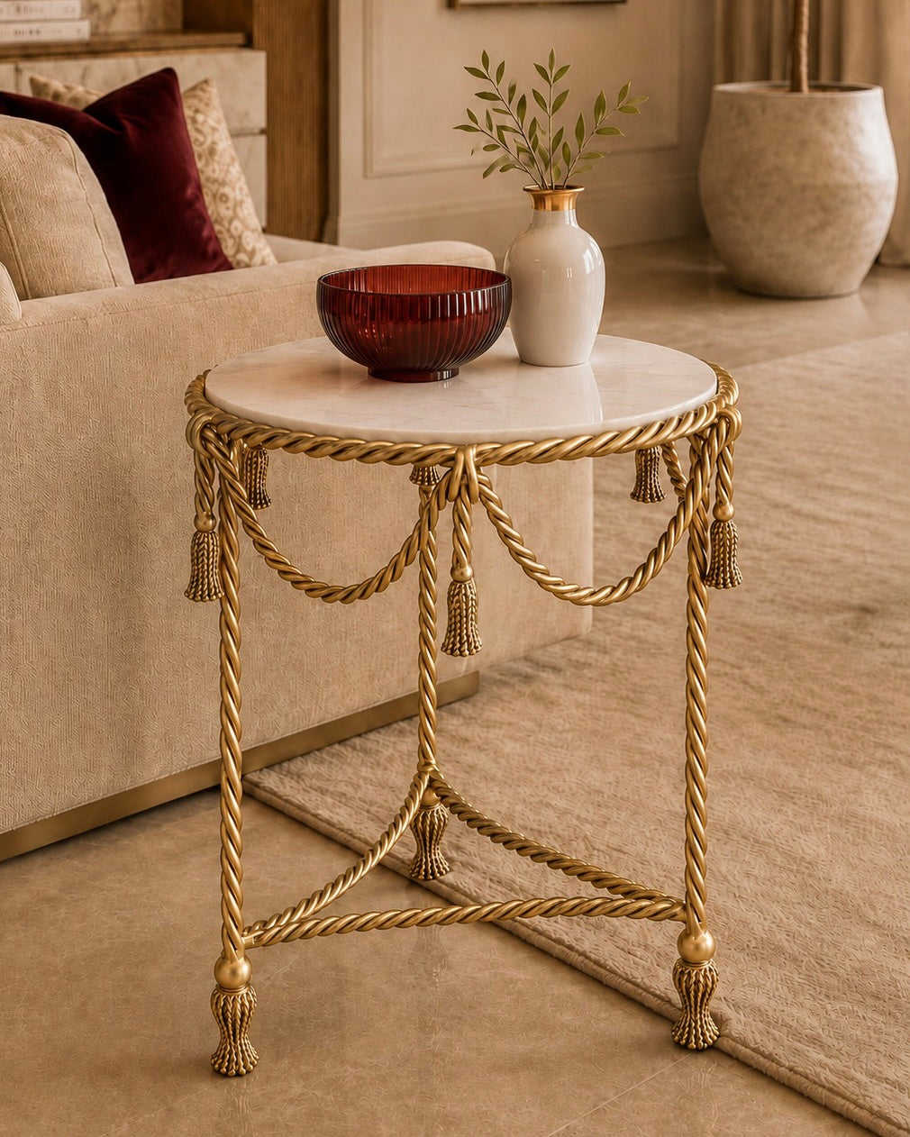 Allegra Side Table in gold finished wrought iron, featuring twisted rope detailing, decorative tassels, and a round marble top.