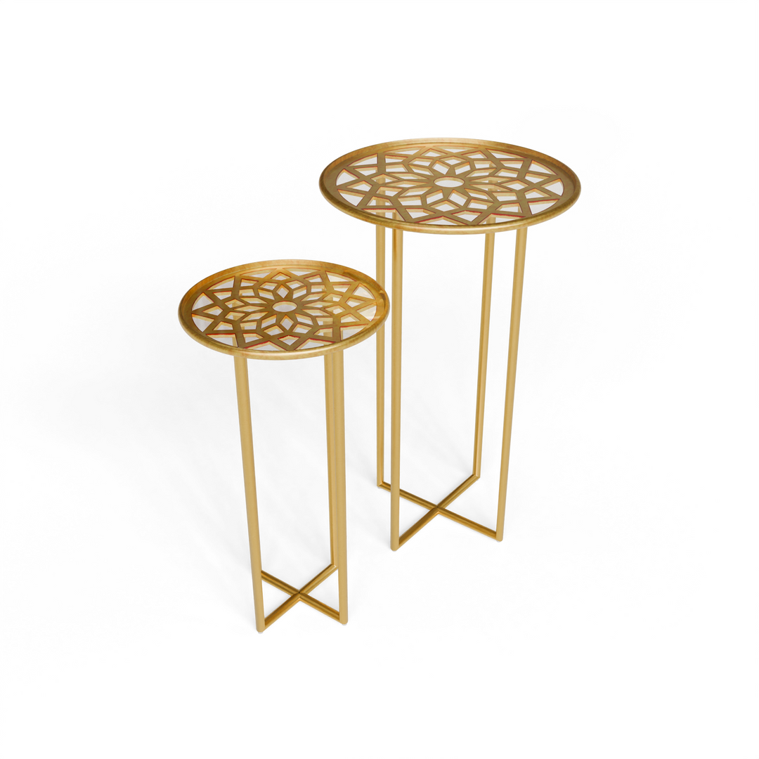 Pair of gold round nesting tables with geometric glass tops, angled front view