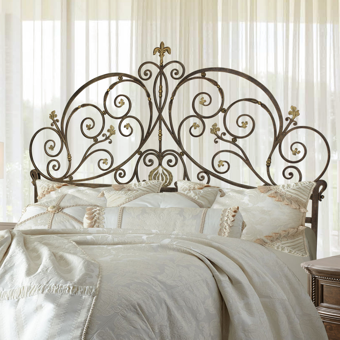 A luxurious wrought iron double bed inspired by Art Nouveau; with scrolls and leaves painted in an antique bronze finish