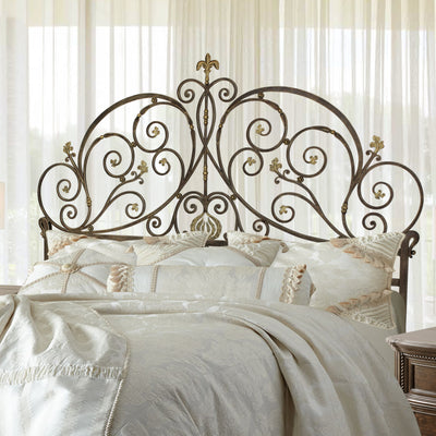 A luxurious wrought iron double bed inspired by Art Nouveau; with scrolls and leaves painted in an antique bronze finish
