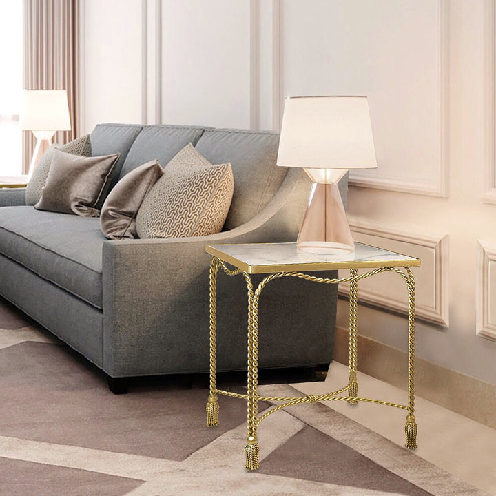 A unique golden accent table inspired by twisted rope stands by the end of a blue couch