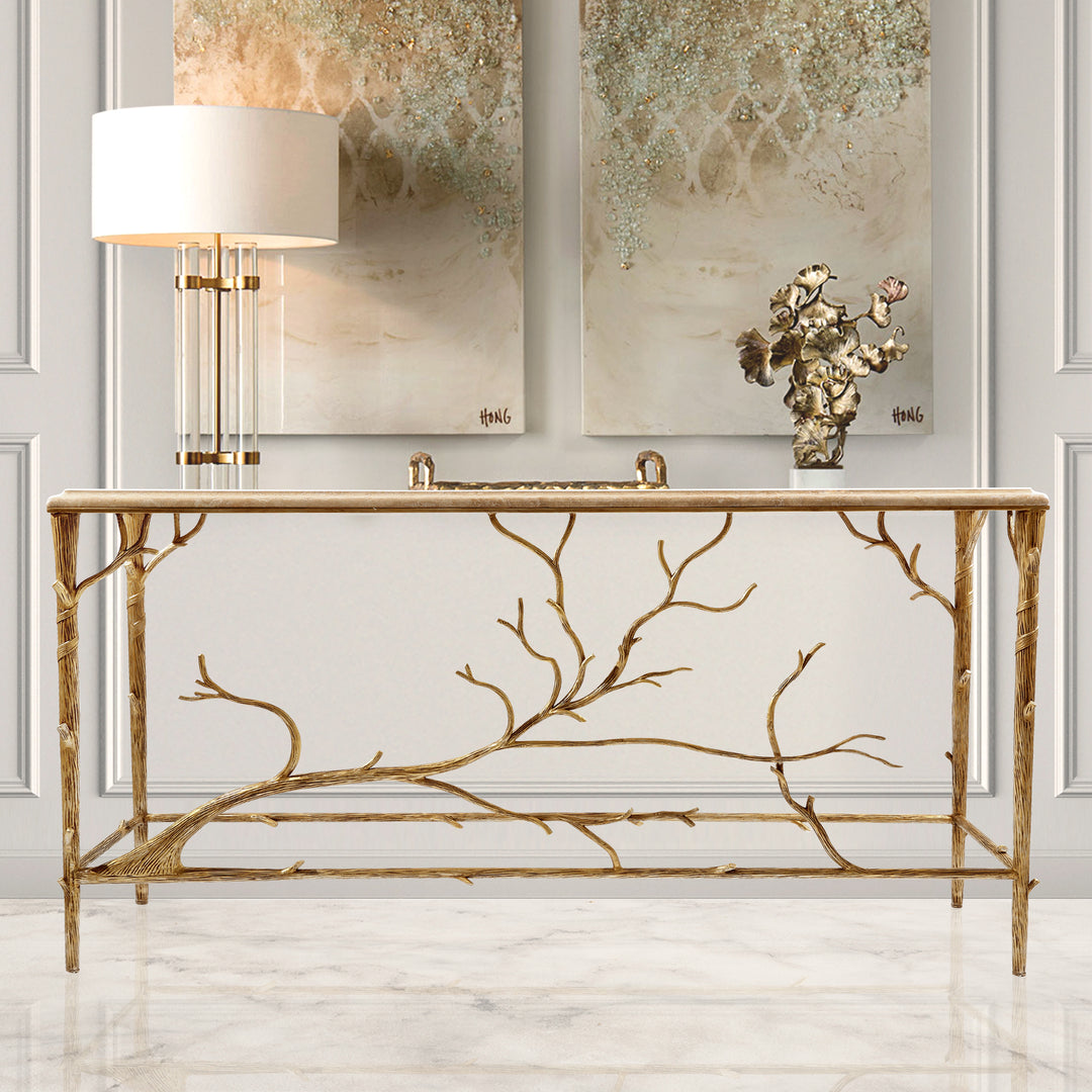 A unique console with an organic branch-inspired base painted in an antique champagne finish, topped with travertine marble in a luxurious living space