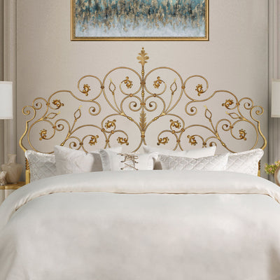 A luxurious wrought iron double bed inspired by nature; with scrolls and leaves painted in an antique gold color