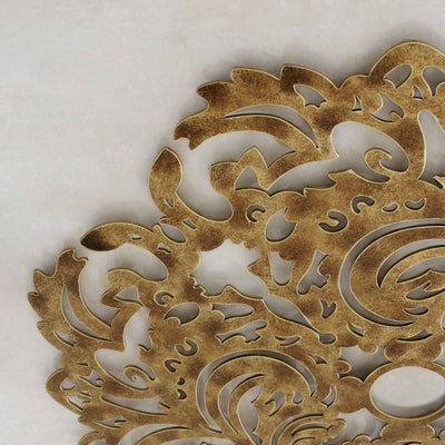 Close up of a decorative metallic ceiling medallion with a lace pattern and gold painted finish