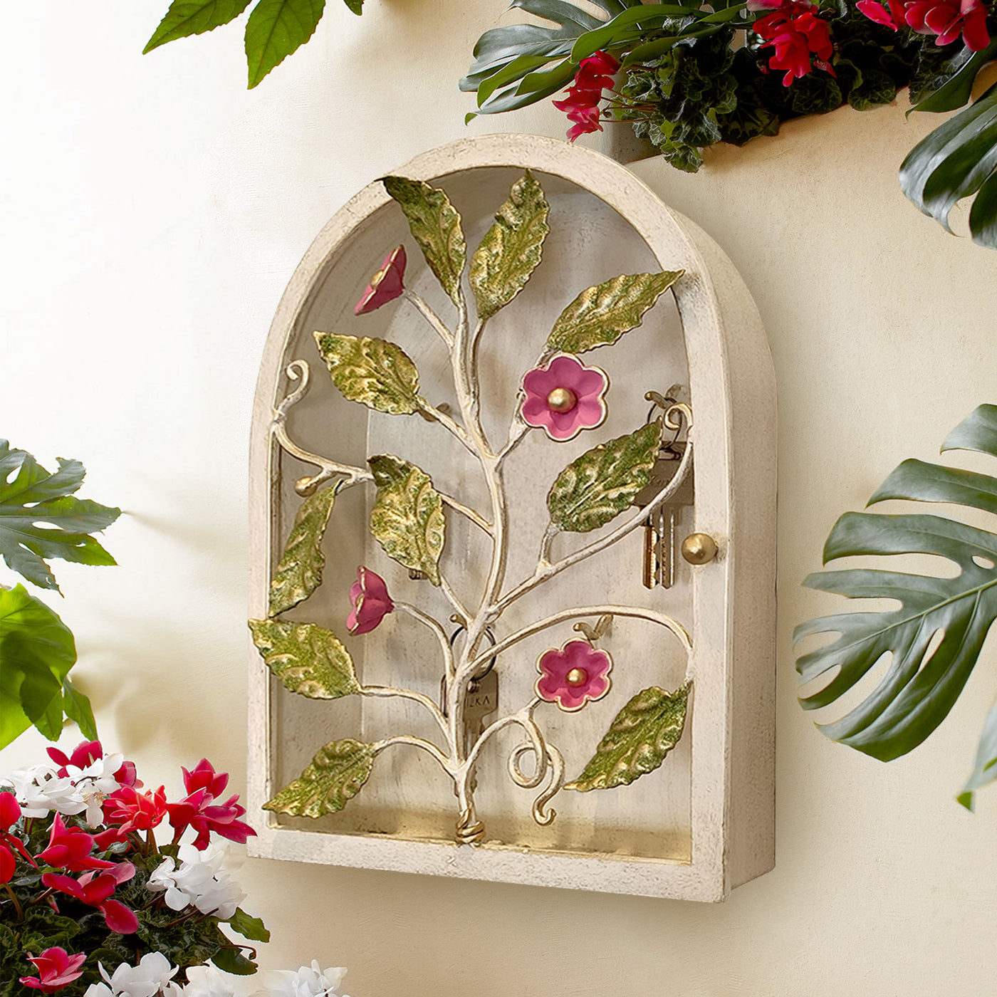 An arched decorative floral key storage box with green leaves and pink flowers