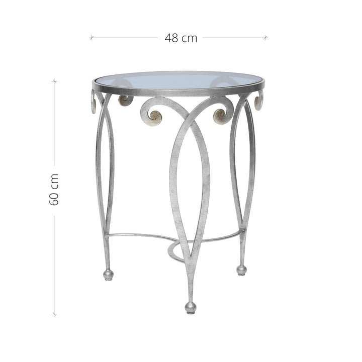 An exquisite silver end table made of metal scrolls topped with a clear round glass
