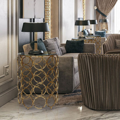 A contemporary living room exhibiting unique accent tables comprised of golden metallic rings topped with clear glass