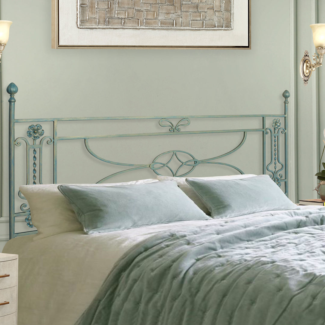 A simple classical wrought iron double bed with scrolls and flowers painted in a pastel blue color, with blue and white beddings