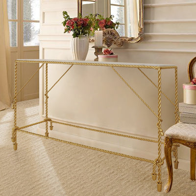A contemporary golden console table with a metal base inspired from twisted rope topped with a white marble