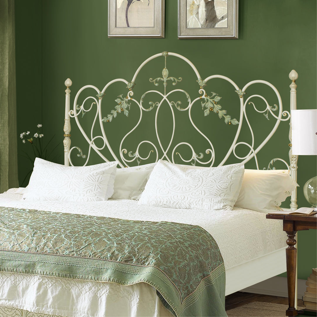 A luxurious wrought iron double bed inspired by nature; with scrolls and leaves painted in an antique finish