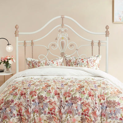 A girly wrought iron single bed with floral beddings