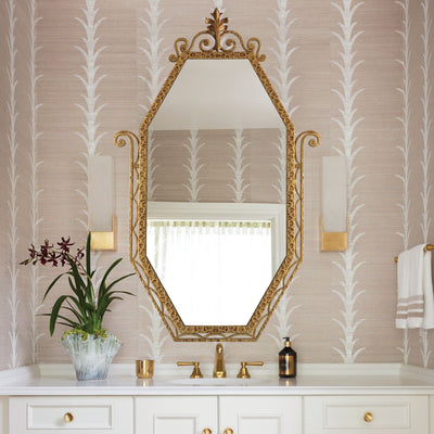 An Art Deco styled wrought iron mirror painted in an antique golden finish hangs above a stylish wash basin 