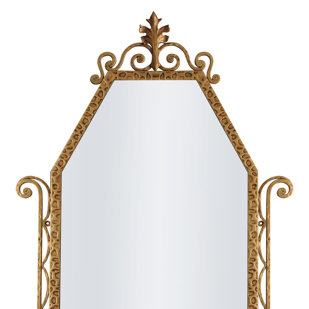 A close up of a classical hand forged mirror with textured scrolls painted in an antique gold finish
