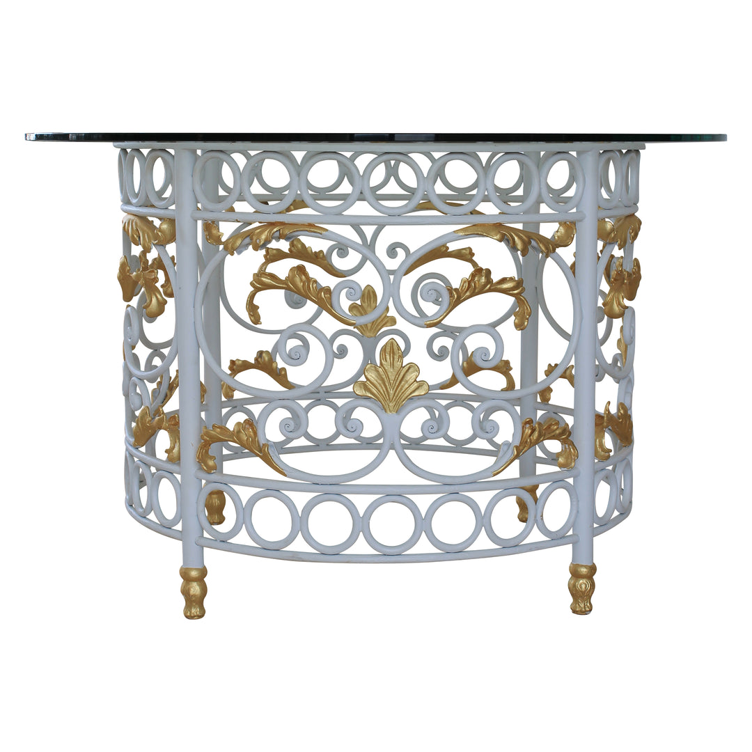 A round entryway table with a classical wrought iron base, topped with a clear circular glass, painted in white and gold