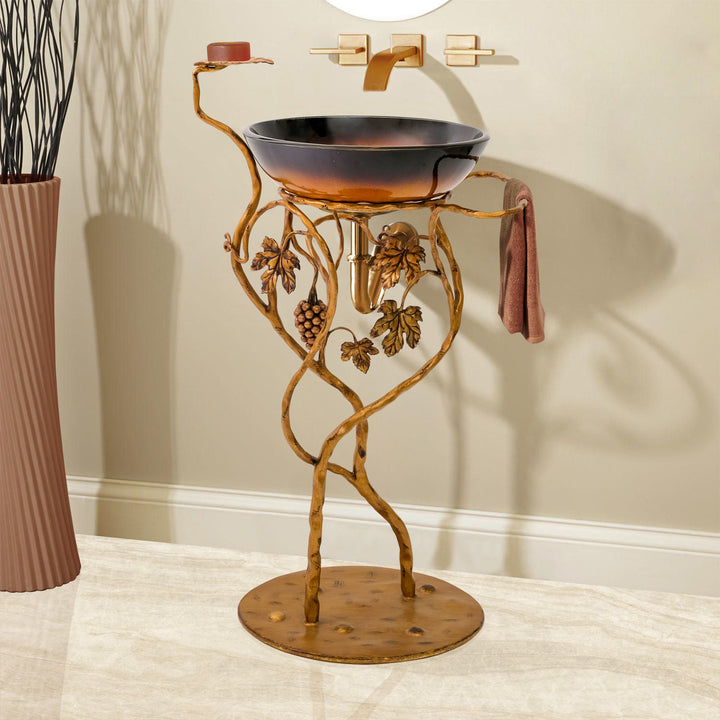 A decorative metal wash basin stand with base inspired by grapes and vines, painted in an antique golden finish