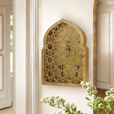 Key cabinet with a geometric pattern and Islamic arched top painted in an antique gold finish mounted on a wall