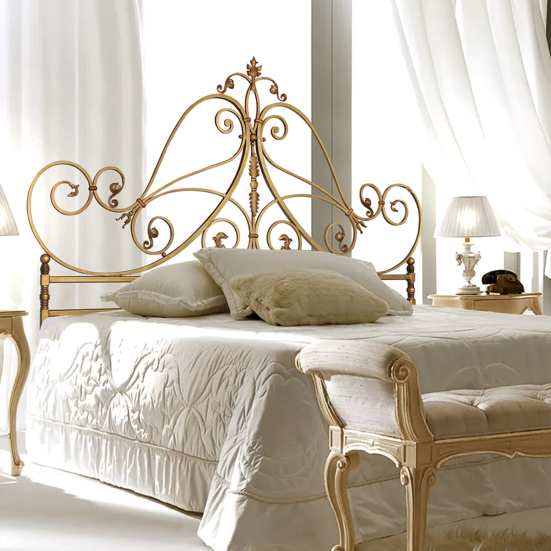 A luxurious wrought iron double bed inspired by the neoclassical style painted in an antique gold finish