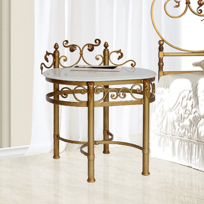 A luxurious wrought iron bedside table inspired by the neoclassical style painted in an antique gold finish