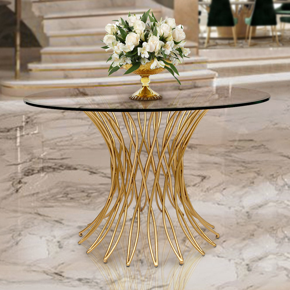A modern round lobby table with a metal golden base and a clear glass top in a luxurious entrance hall